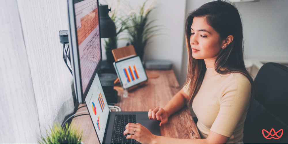 Administrative virtual assistants working efficiently with multiple screens displaying colorful graphs and data analysis.