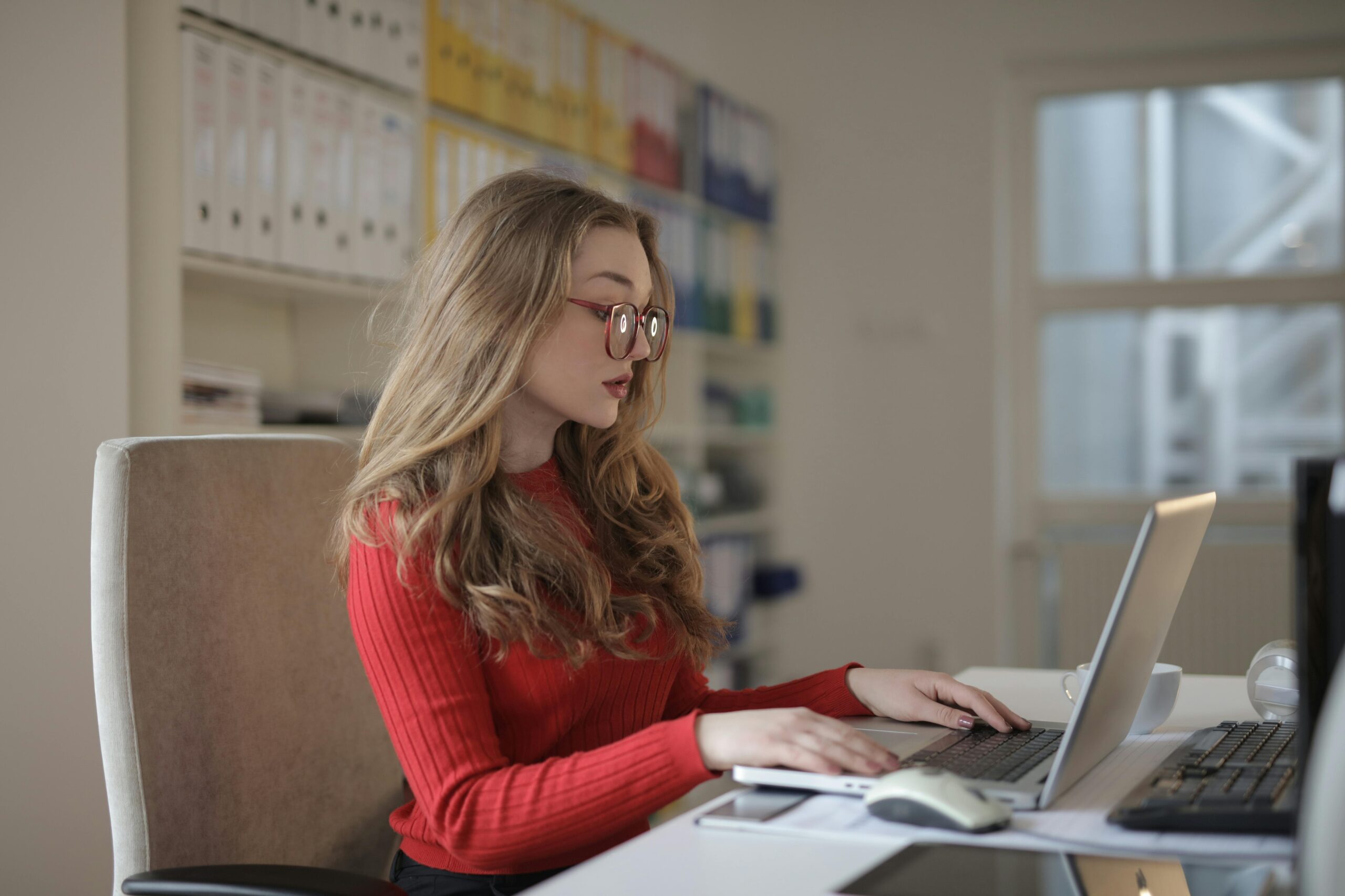 A focused professional working on a laptop in an office.