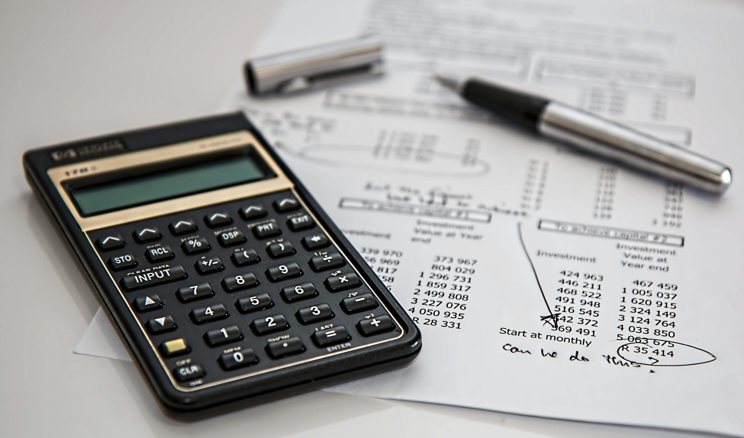 A classic calculator and financial documents emphasizing the benefits of accounting services outsourcing.