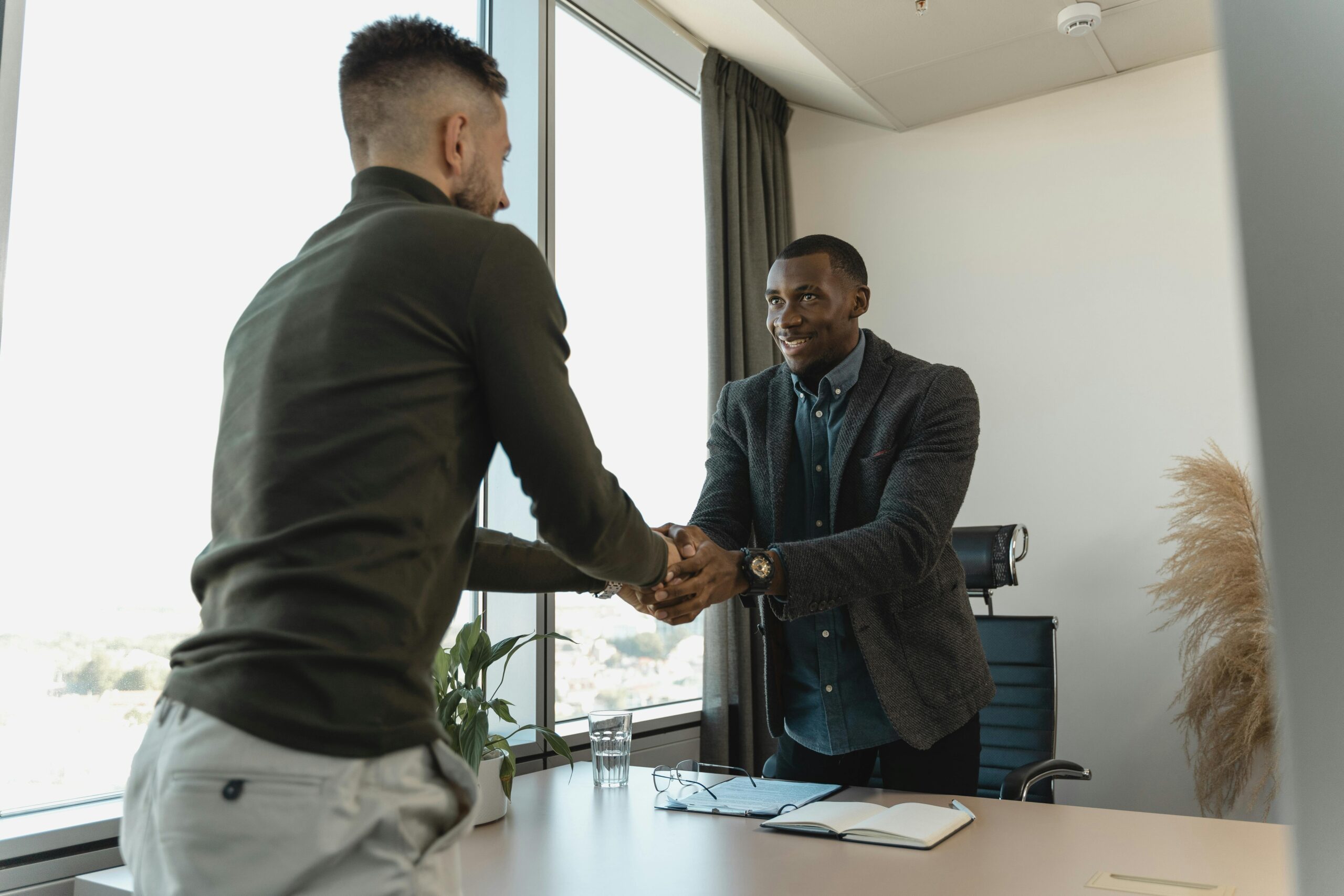 Talent hiring handshake sealing a professional agreement in a modern office.