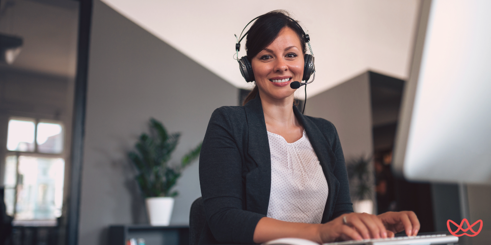 Smiling customer service representative with a headset, showcasing the benefits of outsourcing help desk services.