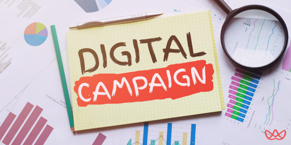 A desk with a notepad labeled "Digital Campaign" surrounded by marketing charts, symbolizing the expertise campaign managers for hire bring to effective digital strategies.