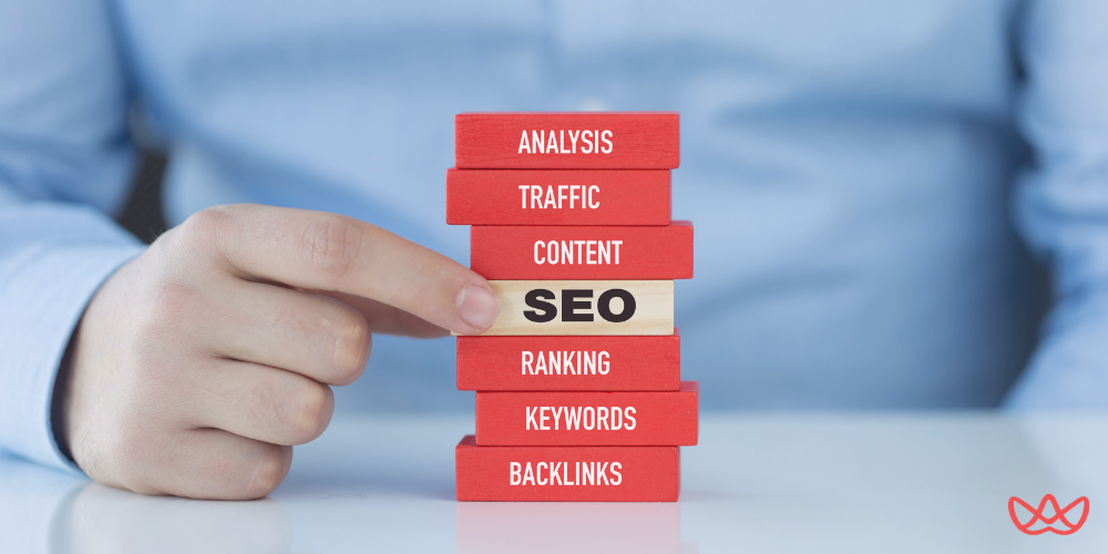 A stack of wooden blocks labeled SEO-related terms, symbolizing the importance of hiring an SEO expert for strategic growth.
