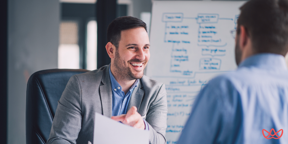 Marketing recruiters connecting with a professional during a one-on-one discussion in a modern office setting.