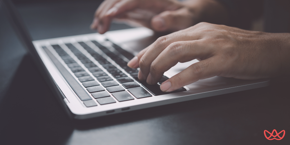 Hands typing on a laptop keyboard, showcasing efficient outsourced network management practices.