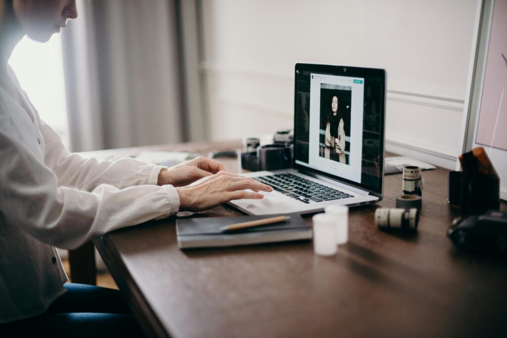 A professional editing photos on a laptop in a calm workspace, symbolizing the importance of why hire a virtual assistant for creative and technical support.