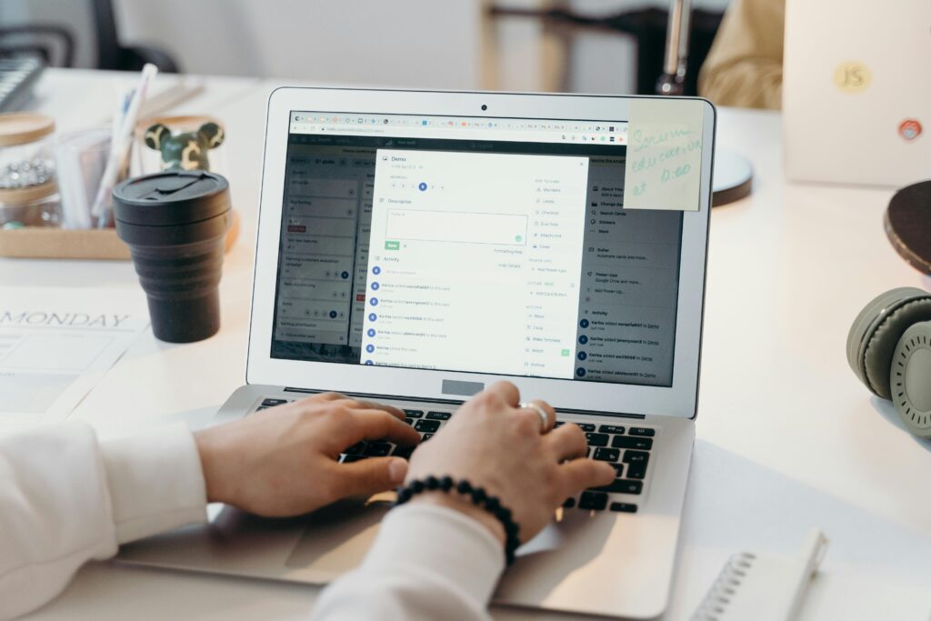 Hands typing on a laptop while managing email marketing tasks, illustrating the organizational benefits of email marketing outsourcing.