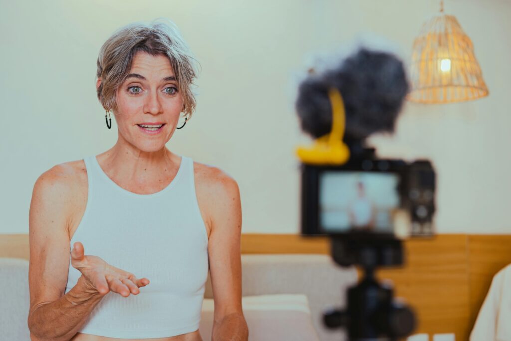 A content creator assistant recording a video for online content creation, with a camera and microphone setup in a home studio.