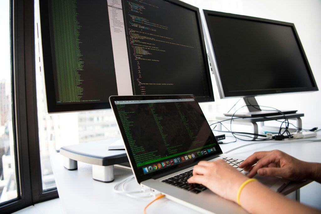 A programmer at a workstation, representing the benefits of outsourcing help desk services for technical support.