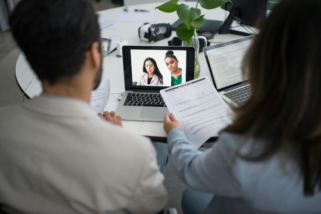 A group of recruiters in a meeting discussing resumes and strategies on how to hire international employees.