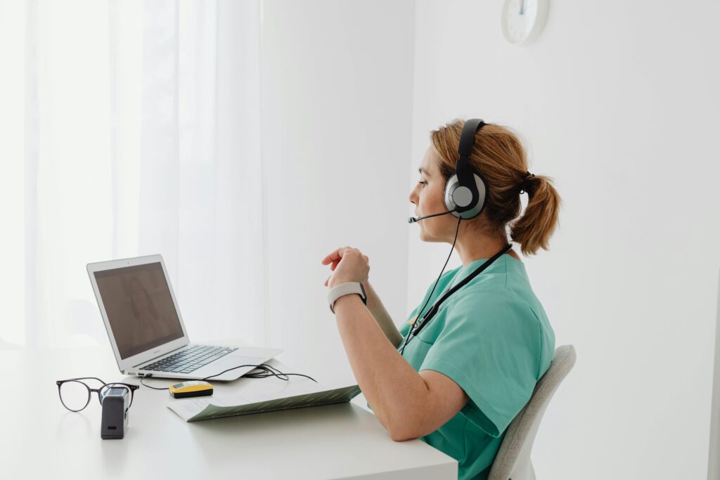 A professional appointment setter in a headset conducting virtual scheduling via a laptop.