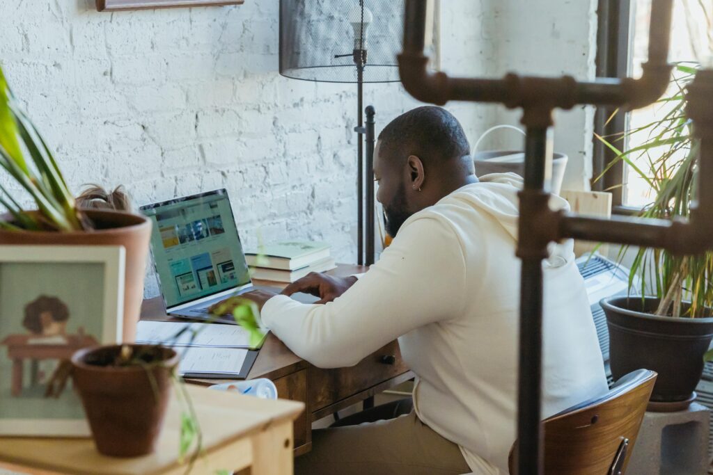 A focused professional working on a laptop in a creative workspace, demonstrating the role of a social media virtual assistant.