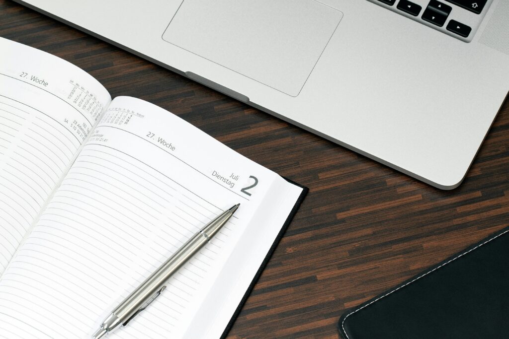 A notebook and pen on a desk, symbolizing the organization skills of an appointment setter.