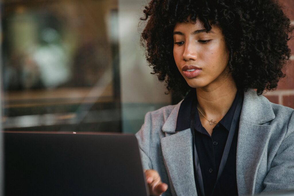 A young woman working remotely on her laptop, highlighting the role of a property management virtual assistant in maintaining seamless property operations.