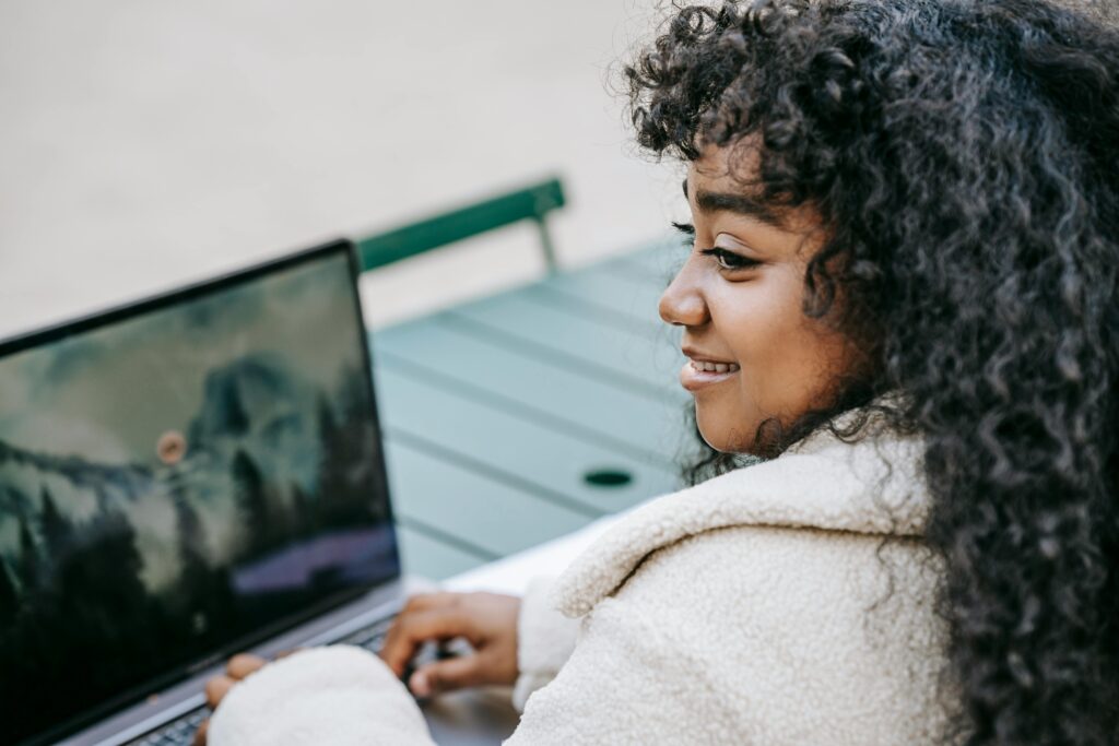 A professional working on a laptop outdoors, emphasizing the flexibility of utilizing an outsourced marketing department.