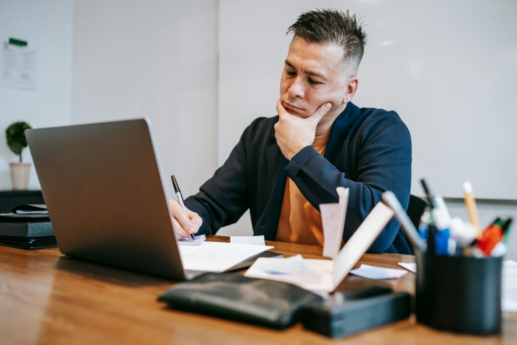 A focused professional reviewing documents at a desk, emphasizing strategic planning as a key feature of examples of outsourcing companies.