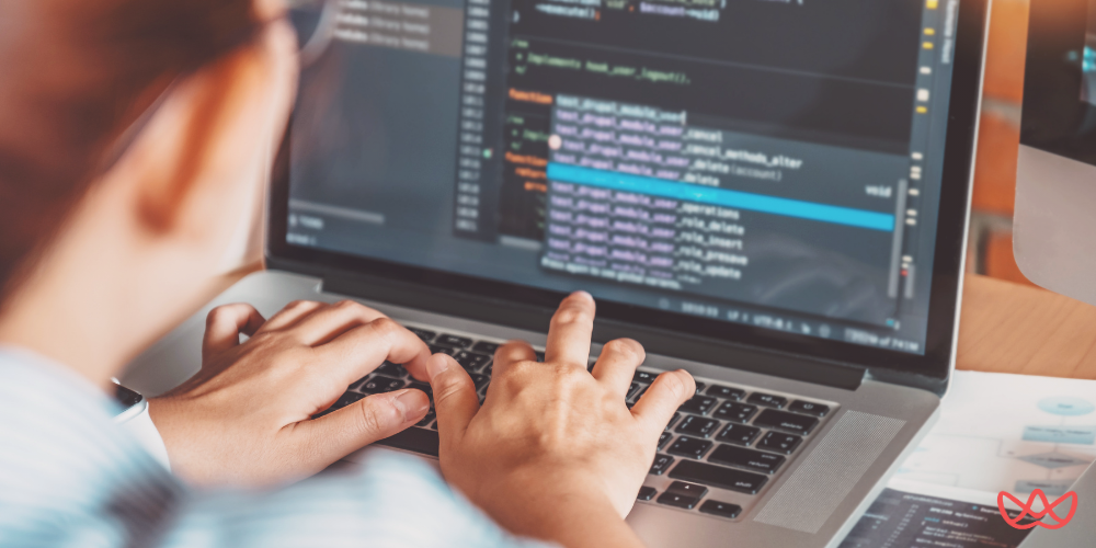 Person typing on a laptop displaying code editor with various functions listed in the dropdown menu, emphasizing backend developer key skills.