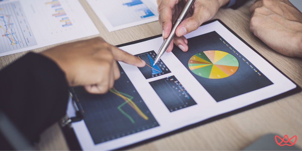 Digital marketing consultant key skills summary being reviewed on tablet, showing colorful pie charts and performance graphs during a business analysis meeting.