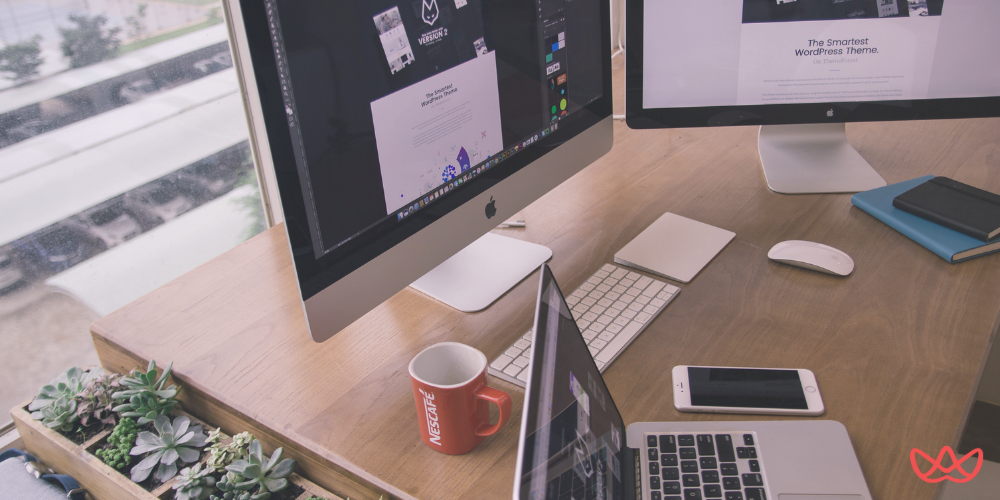 Two computer monitors displaying design work, a laptop, and a coffee mug on a desk, illustrating digital product designer key skills summary through a modern workspace setup.