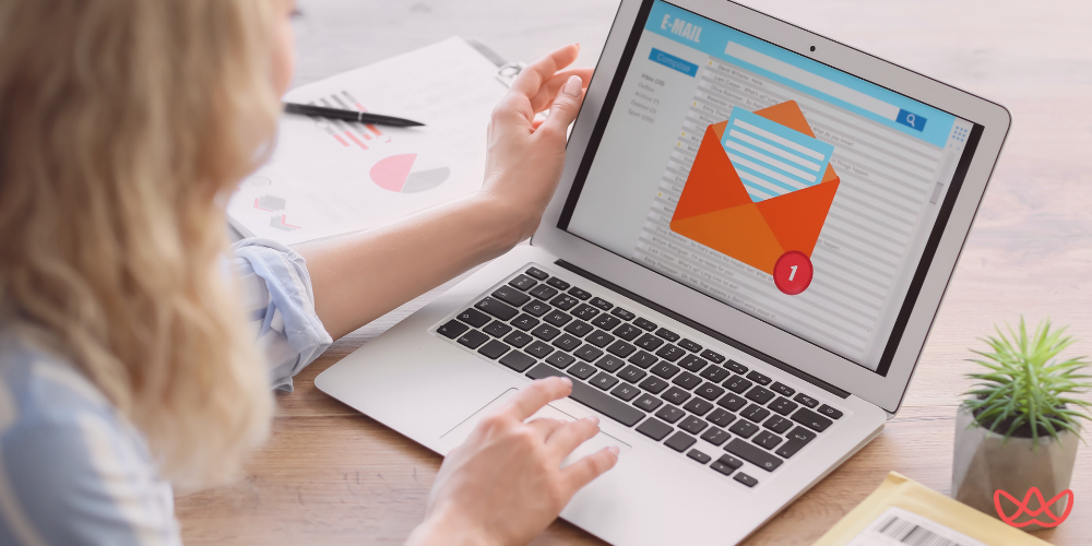 A person is working on a laptop displaying an email inbox with one new message notification, illustrating the email marketing specialist key skills summary.