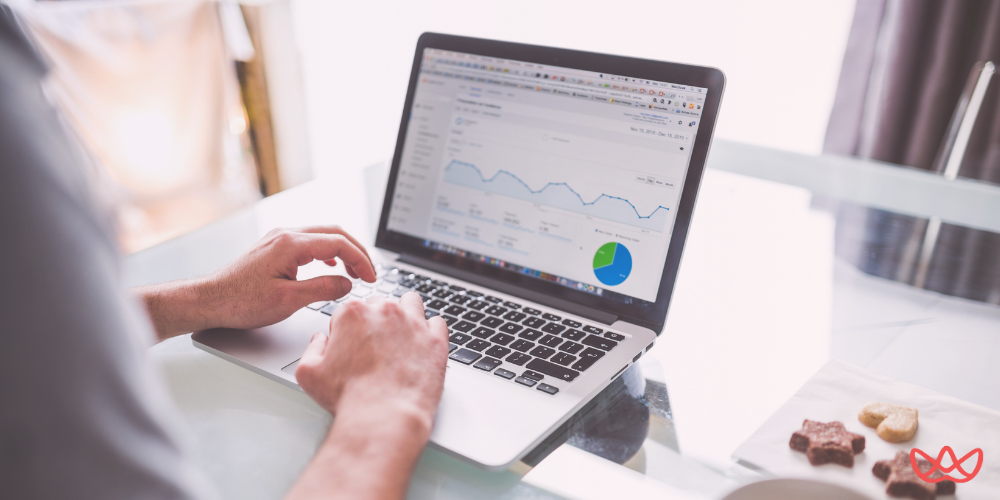 A marketing strategist is analyzing data on a laptop, focusing on key skills summary, with graphs and charts displayed on the screen.