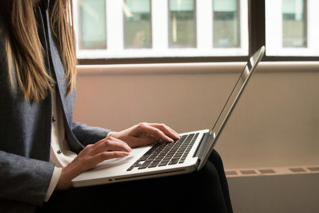 A person typing on a laptop, illustrating the copywriter key skills summary.