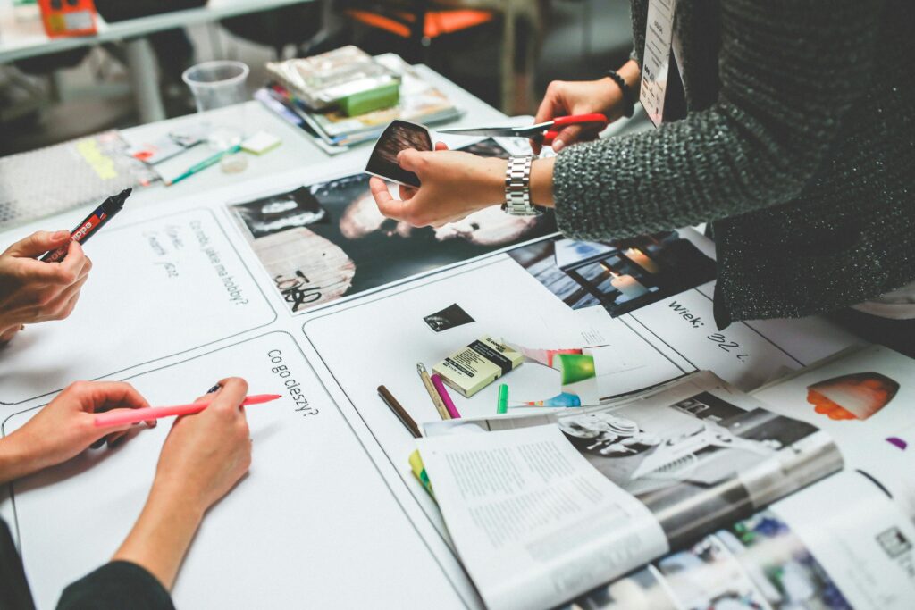 Digital marketing consultant key skills summary being demonstrated through creative planning session with mood boards, photographs, and design materials spread across a white table.