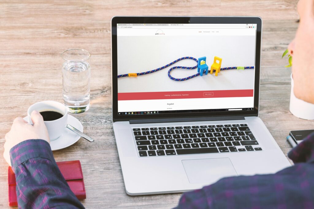A person holding a cup of coffee while looking at a laptop screen displaying a website with colorful chairs and a rope, representing a Wix developer key skills summary.