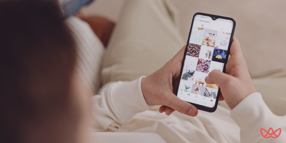 A person holding a smartphone, browsing an Instagram profile grid filled with vibrant visuals, representing the Instagram Reels & Shorts specialist key skills summary.