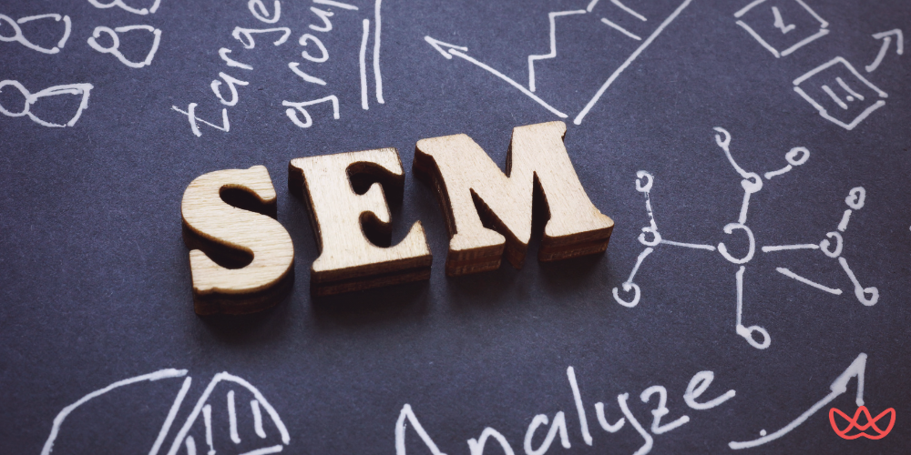 "SEM" wooden letters placed on a chalkboard, surrounded by marketing doodles and terms like "target group" and "analyze," illustrating an SEM Manager Key Skills Summary.