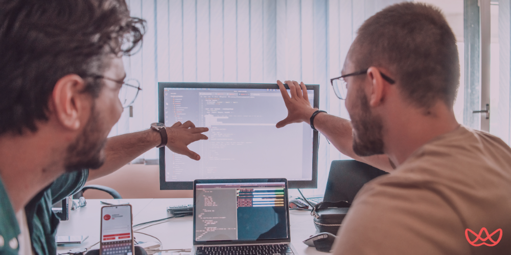 A workspace setup with a monitor displaying a Webflow editor, surrounded by tools and resources essential for webflow developer key skills summary.