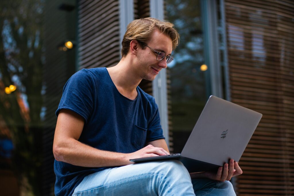 A conversion rate optimization (CRO) specialist key skills summary being reviewed on a laptop by a person sitting outdoors in a casual setting.