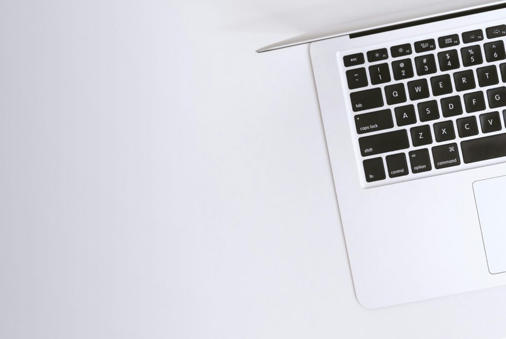Minimalist image of a white MacBook laptop with black keyboard, showcasing clean design and professional workspace for SEM management.