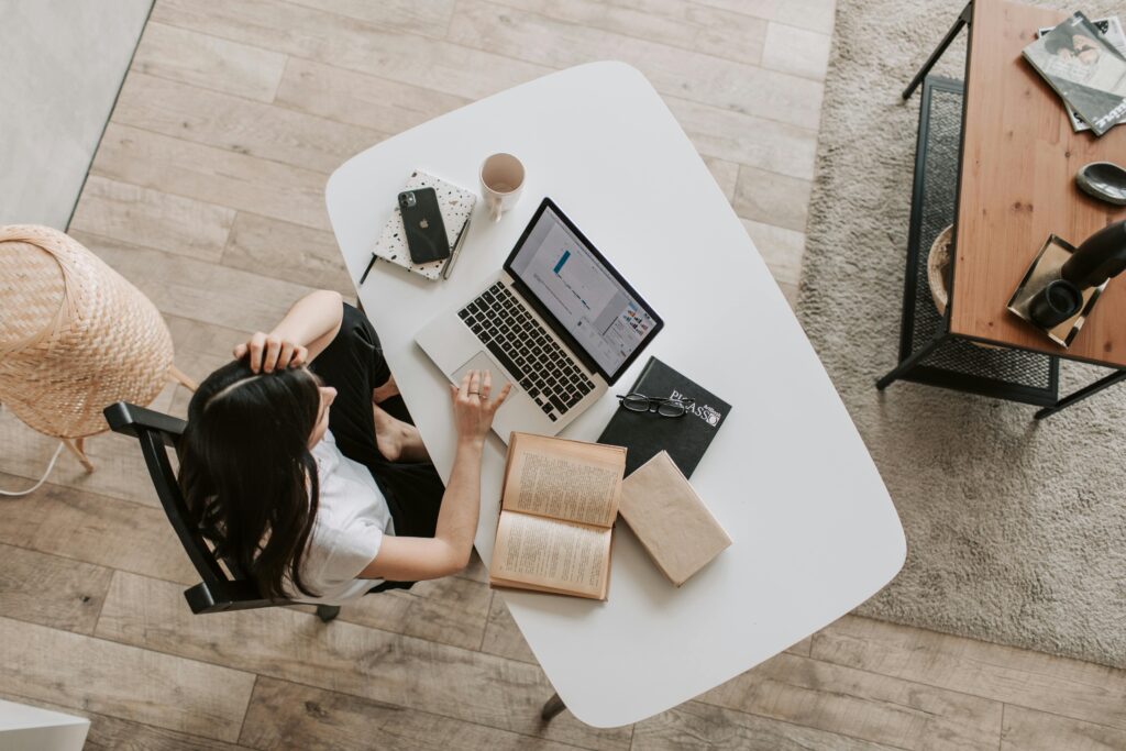 Top-down view of a workspace featuring a laptop displaying analytics, surrounded by a notebook, coffee cup, and books, highlighting the SEO content writer key skills summary.