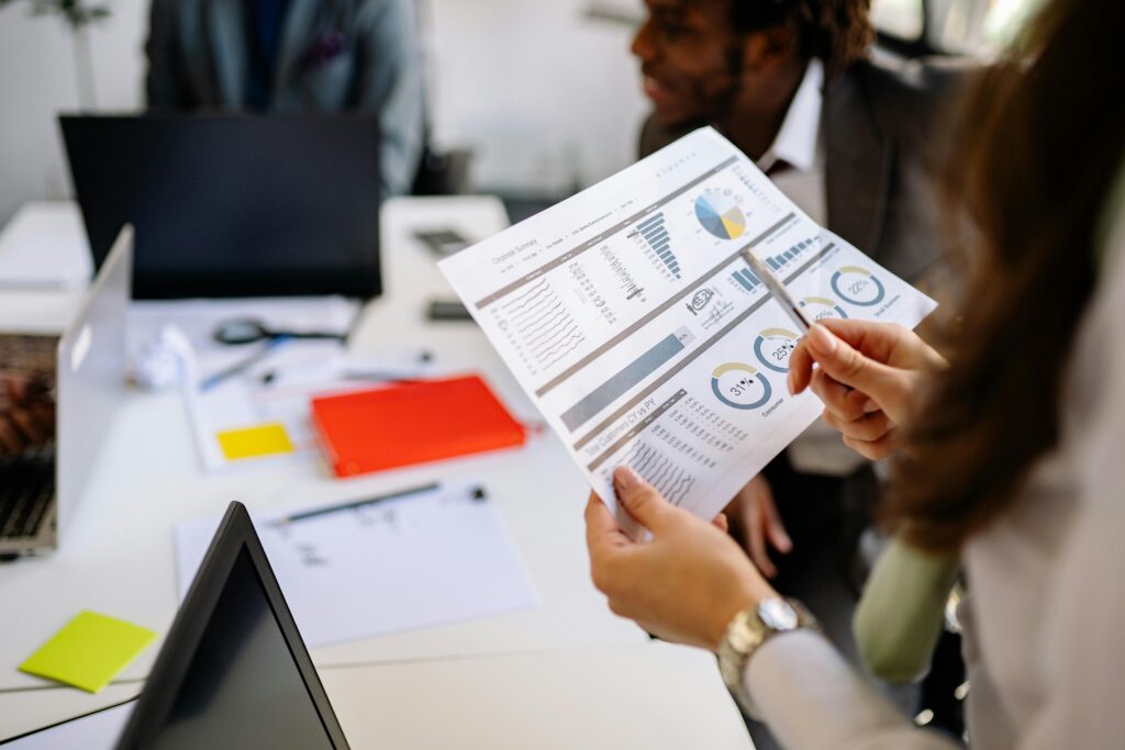 Colleagues reviewing marketing analytics and charts in a meeting, ideal for a Performance Marketing Manager Resume Template.