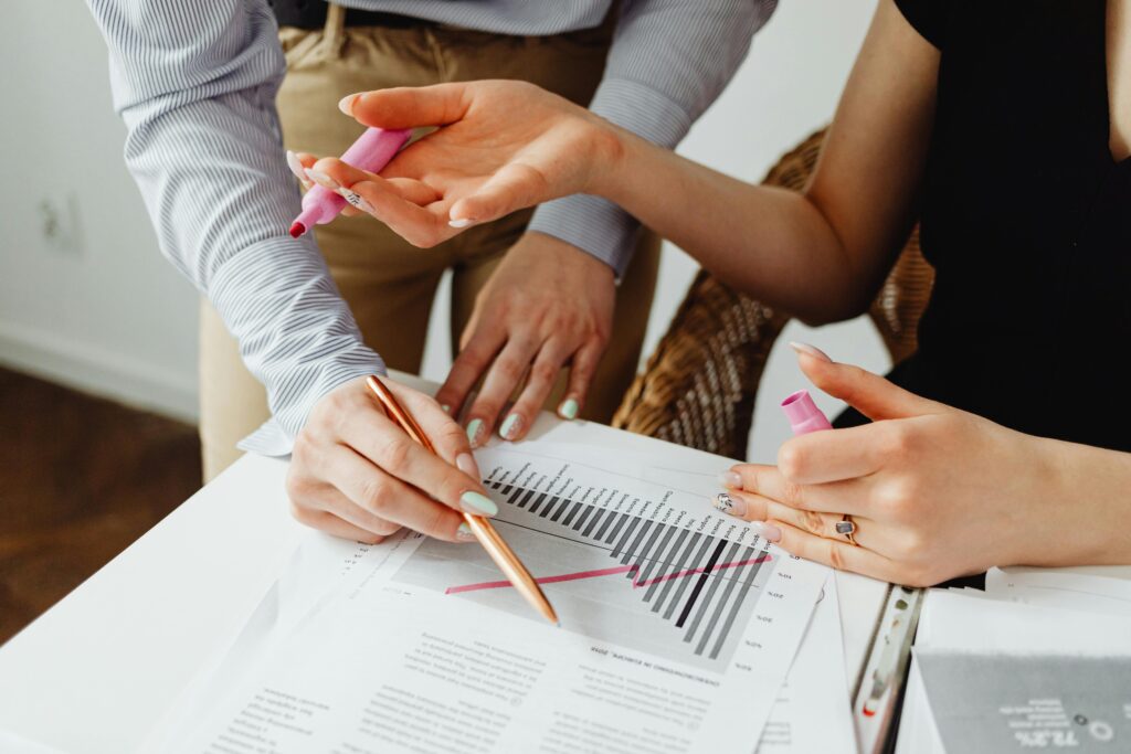 Close-up of two professionals analyzing graphs and highlighting data, suitable for a Performance Marketing Manager Resume Template.