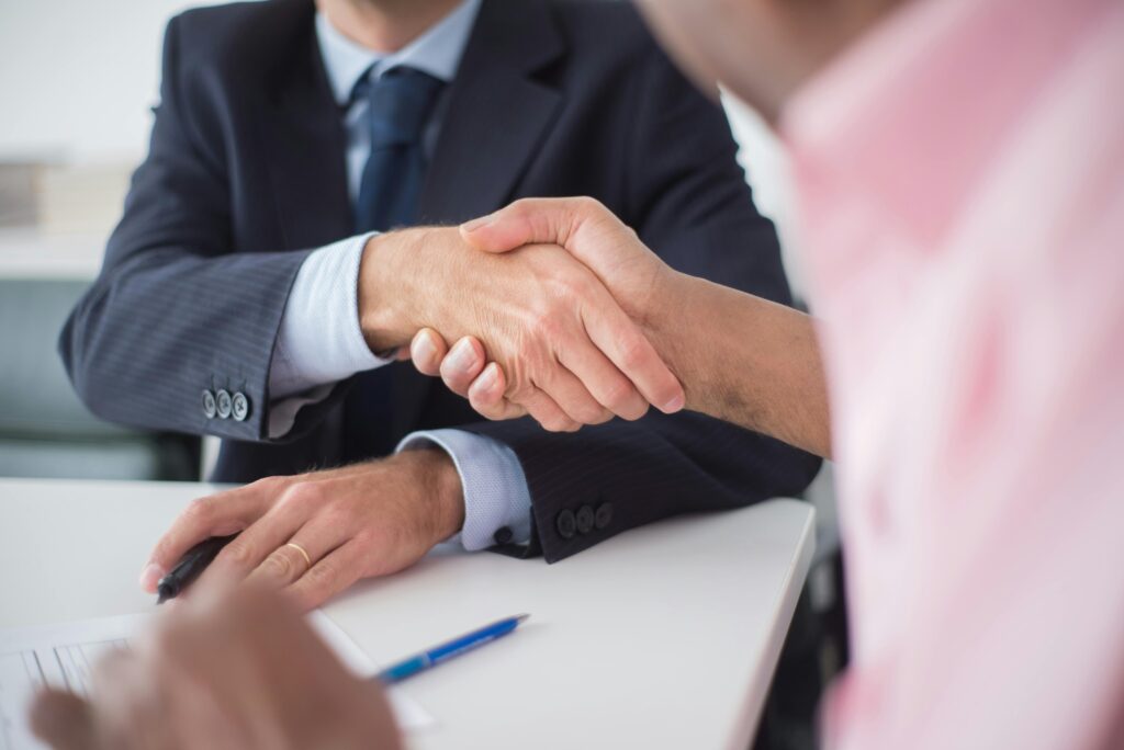 A close-up of a professional handshake between two businesspeople, symbolizing strong client relationships—perfect for a Client Success Manager Resume Template.