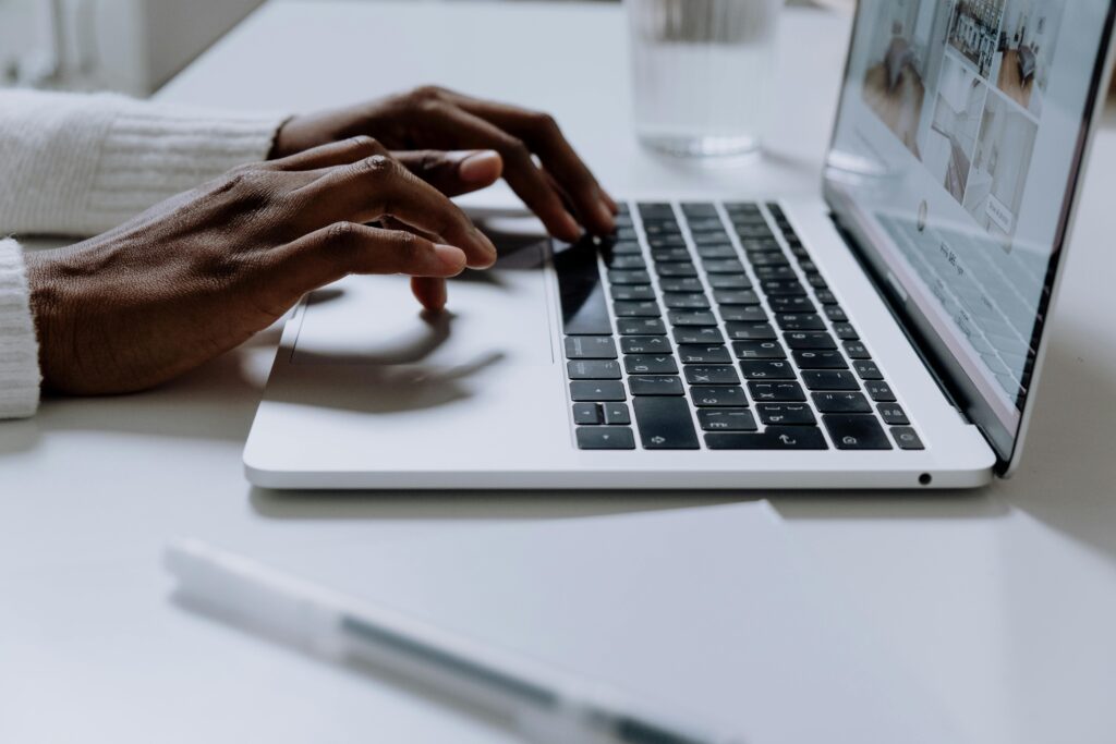Hands typing on a laptop keyboard, representing the detailed work involved in Why to Outsource SEO?