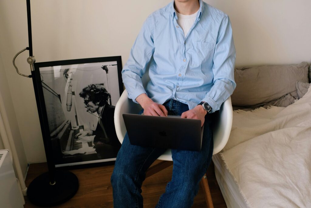 Professional working on laptop in modern home office setup, researching how to outsource multilingual SEO services for global business expansion and international market reach.