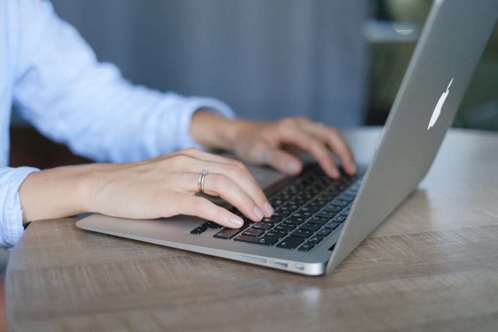 Professional typing on laptop researching how to select the right RPO provider in modern office.