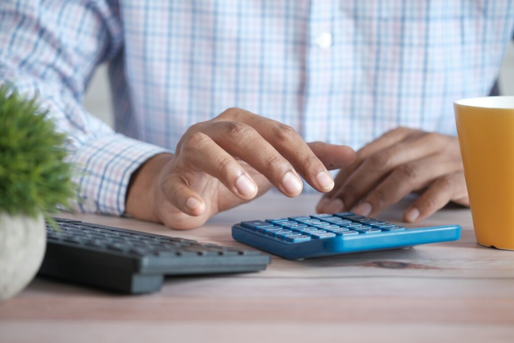 Close-up of a person's hands typing on a laptop keyboard, with the laptop screen showing what appears to be a web browser or application, and the text "Hired by Offshore Accountant Comprehensive Guide" is visible on the image.